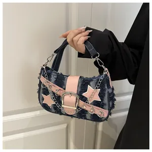 Detail van Y2K denim handtas met ster, roze lederen flap en zilveren kettingaccenten