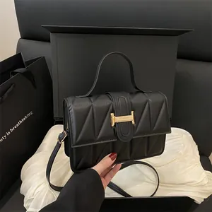 Schwarze gesteppte Lederhandtasche mit goldener H-Schnalle auf weißer Seide