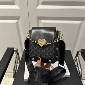 Bolso pequeño para móvil en color negro con cierre de corazón dorado y logo