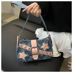 Detail van Y2K denim baguette tas met roze sterrenpatch en zilveren metalen studs