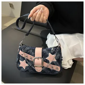 Detail van de Y2K denim ster schoudertas met roze lederen biezen en metalen gespen