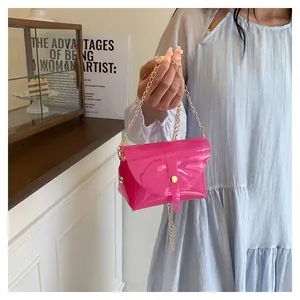 Détail du sac enveloppe en PVC transparent rose avec bandoulière chaîne dorée