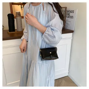 Détail d'un sac gelée avec chaîne dorée sur fond de robe bleu clair