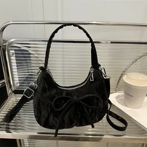 Schicke schwarze Hobo-Tasche mit Falten, großer Schleife und silbernen Details