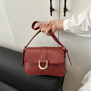 Elegante dieprode crossbodytas met slangenreliëf en een gouden U-vormige gesp