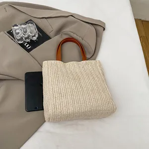 Kontrast-Strohbeutel mit braunen Ledergriffen und geräumiger beige Webstruktur