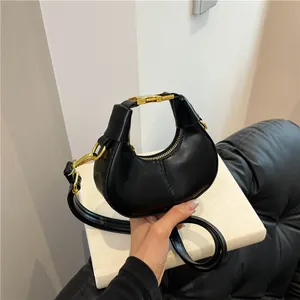 Sac à main croissant noir chic avec détails dorés et bandoulière réglable