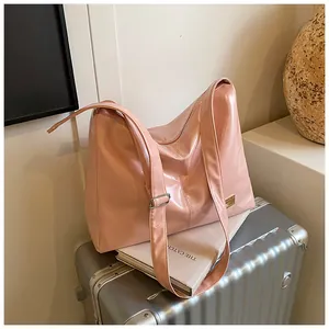 Detail of light pink patent leather tote bag with glossy finish and silver buckle
