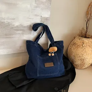 Blaue Denim-Tragetasche im Retro-Stil mit Lederanhänger und Plüschfigur auf Schwarz