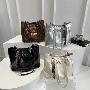 Minimalist oil wax leather tote bags with metal bow in brown, silver, black, and cream