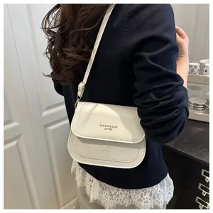 White PU leather saddle bag detail with star embossing and gold fashion lettering