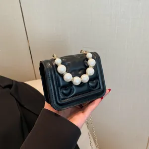 Mini black PU leather handbag with heart quilting, pearl handle and gold chain strap
