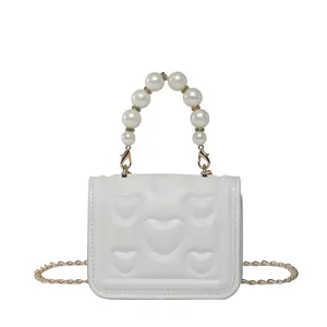 Mini white PU leather handbag with heart embossing and elegant pearl handle strap