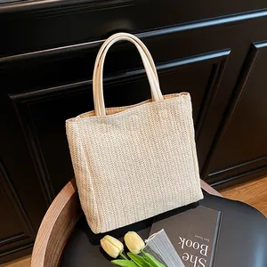 Minimalist beige woven straw tote bag with round leather handles for summer beach use