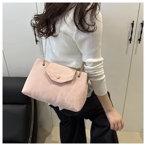 Detail of light pink marble pattern shoulder bag with gold chain and flap closure