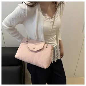 Close-up of pink marble texture shoulder bag with golden chain strap on shoulder