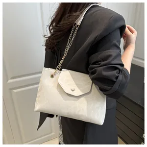 Macro detail of creamy white marble texture handbag with gold chain strap and round buckle