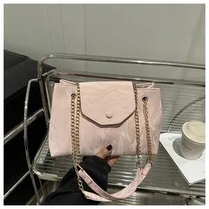 Close-up of pink chain shoulder bag with marble texture and gold metal strap