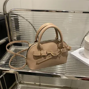 Retro apricot bowling bag with gold hardware on a modern display stand
