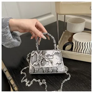 Detail showing the snake skin texture on women shoulder bag with silver bow buckle accessory
