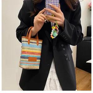 Detail of colorful striped woven mini bag with leather handle and FASHION label