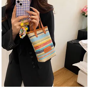 Close-up of colorful striped woven handbag with brown leather strap and fashion tag