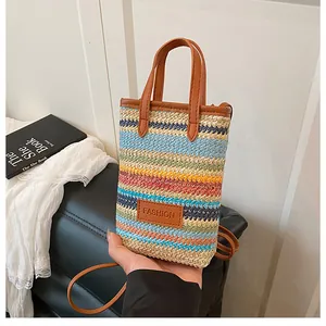 Detail of colorful striped woven mini bag with brown leather trim and fashion patch