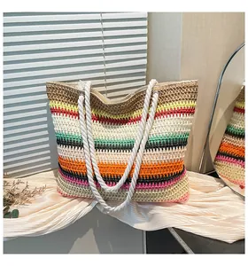 Gros plan sur un sac fourre-tout en paille rayé avec des anses en corde de coton