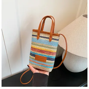 Detail of colorful striped woven mini bag with brown leather handle and fashion tag