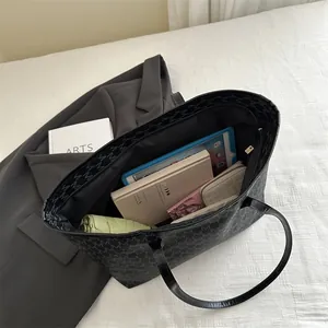 Large vintage black tote bag with M letter print and items showing its capacity