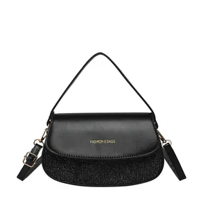 Chic black semicircular handbag with glitter patchwork and golden fashion logo detail