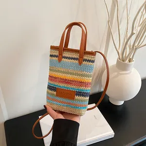 Colorful striped woven mini crossbody phone bag with brown leather handles and fashion tag