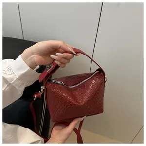 Détail du sac à main tissé rouge avec fermeture éclair en métal et bandoulière réglable