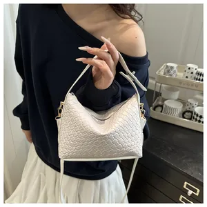 Détail du sac hobo tressé blanc avec texture croisée et finitions métalliques dorées