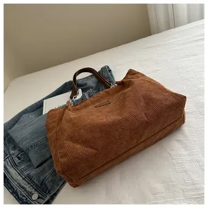 Detail der karamellfarbenen Cord-Einkaufstasche mit Rippstruktur und Lederriemen