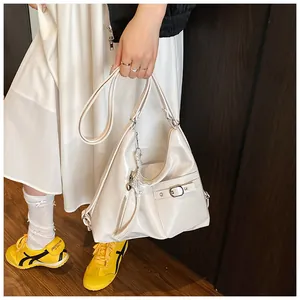 Detail of off-white PU leather tote with decorative zipper and pearl charm accessory