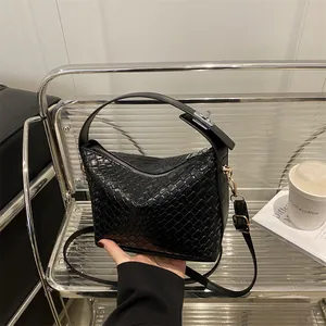 Sac à main tissé noir élégant avec bandoulière réglable et détails en argent chic