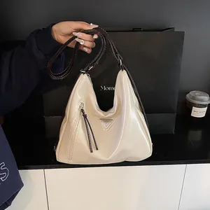 Sac cabas rétro en cuir verni crème avec anses marron foncé et logo triangulaire