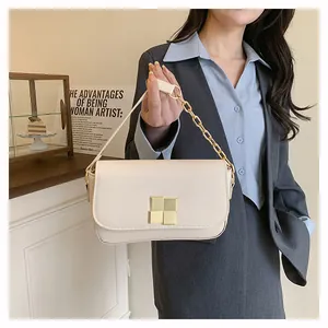 Detail of cream flap crossbody bag with square gold buckle and chain handle