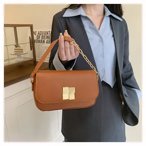 Close-up of brown leather handbag with gold interlocking buckle and chain strap