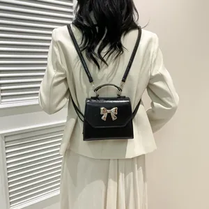 Mini black PU leather backpack for women with silver bow clasp and elegant thin shoulder straps