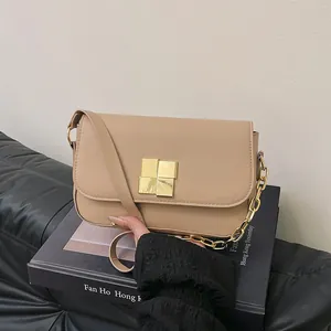 Elegant beige crossbody bag with gold square buckle and decorative metal chain