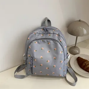 Floral print mini purple backpack with multi-layer zippers for women on a desk