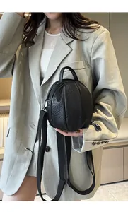 Detail of round basketball shaped crossbody bag with lychee pattern and wide strap