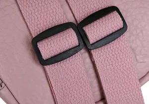 Detail of pink lychee grain leather with adjustable fabric straps and black buckles