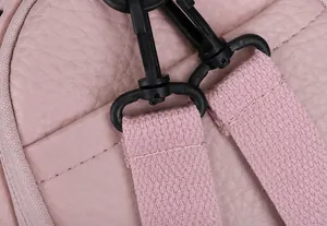 Detail of pink lychee texture PU backpack showing reinforced triangular stitching and strap hook