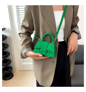Dettaglio mini borsa a tracolla verde con trama intrecciata e hardware in metallo oro