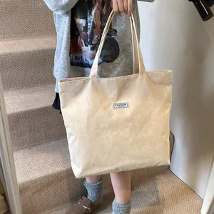 Dettaglio della borsa tote in velluto a coste beige con etichetta Fashion Instinct
