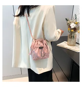 Dettaglio mini borsa a tracolla in nylon rosa con chiusura a coulisse e pieghe su modella