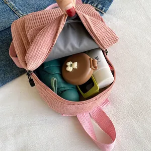 Pink corduroy mini backpack for women showing spacious interior with daily essentials